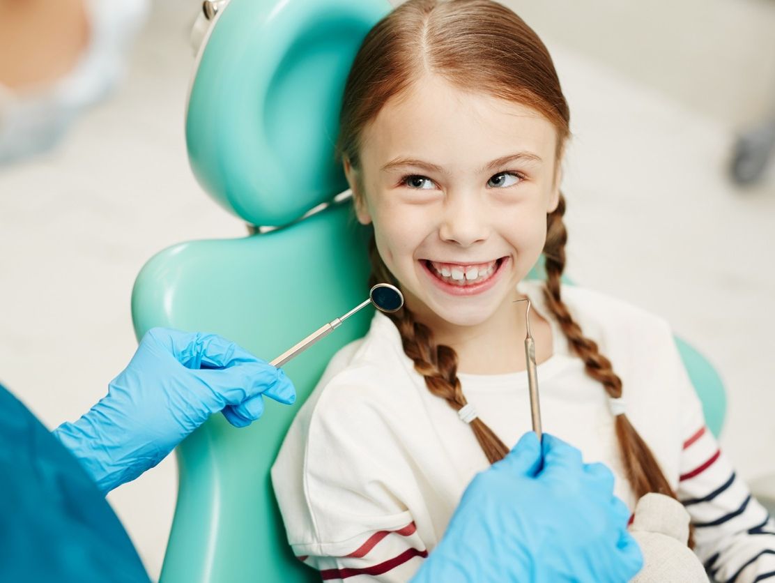 niña en dentista cara feliz