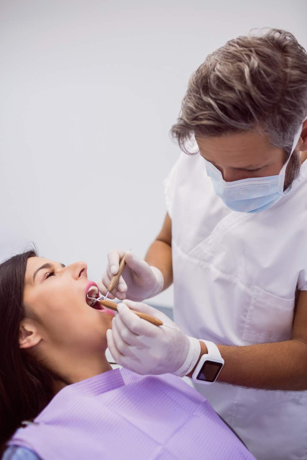 Clínica dental Prevent dentista-examinando-dientes-paciente-femenino