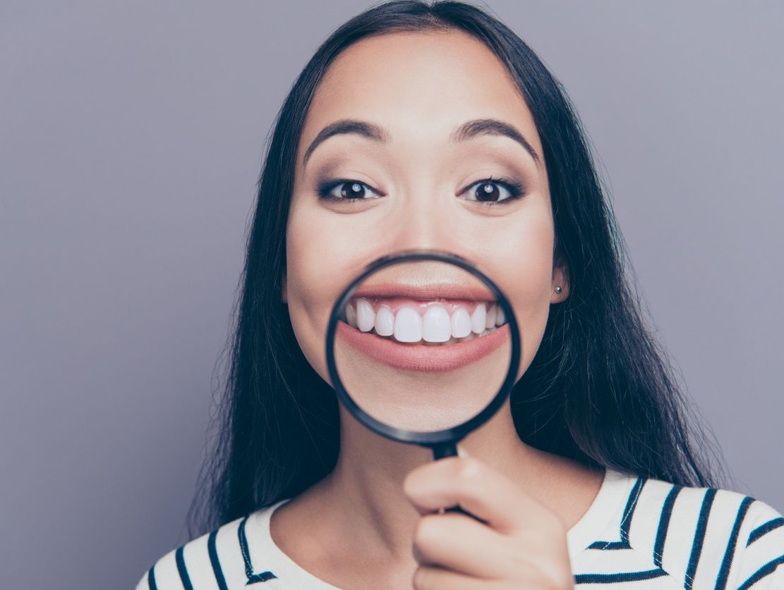 chica con lupa en la boca sonriendo